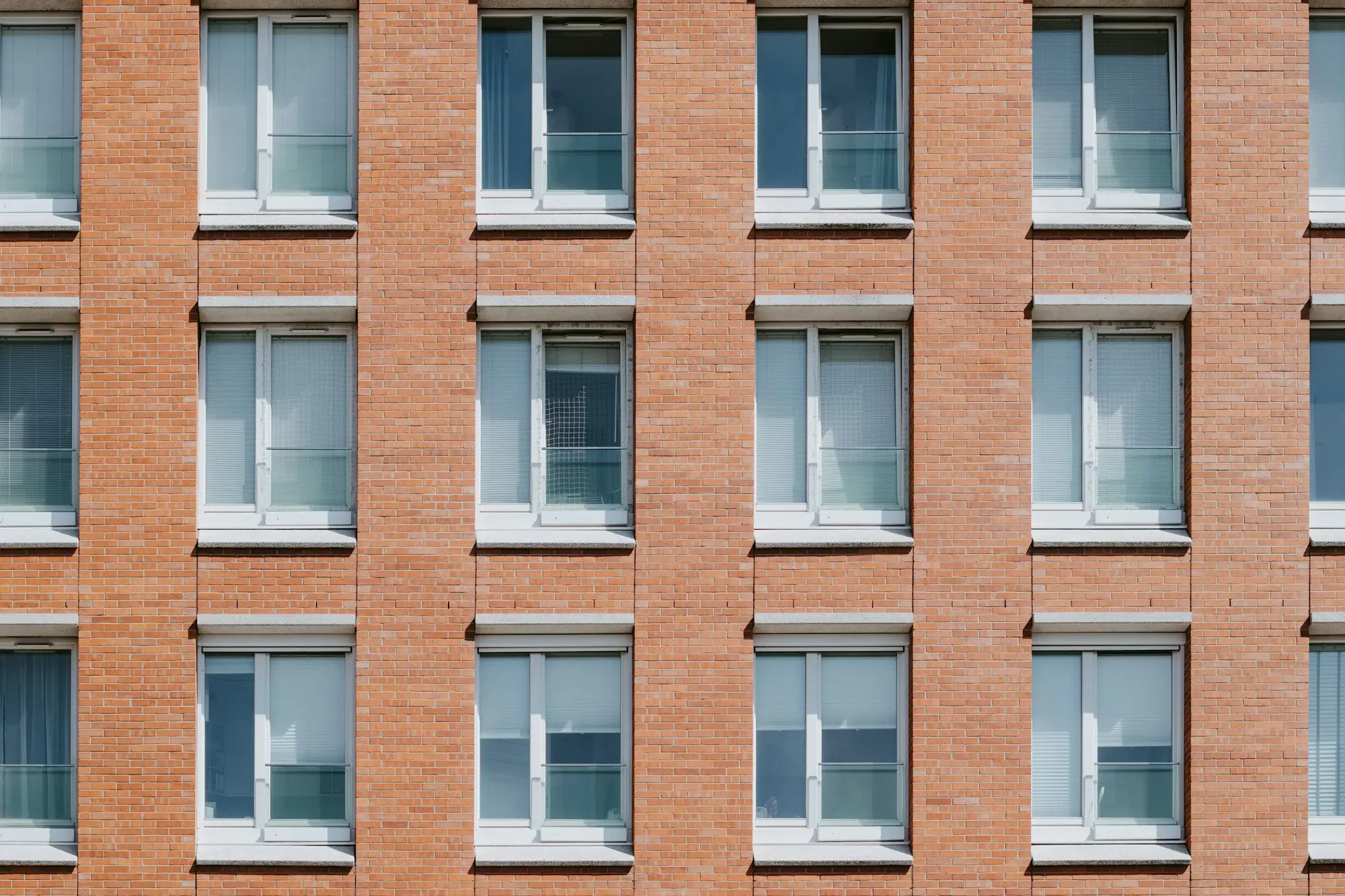 Grid of windows across a red brick office facade
