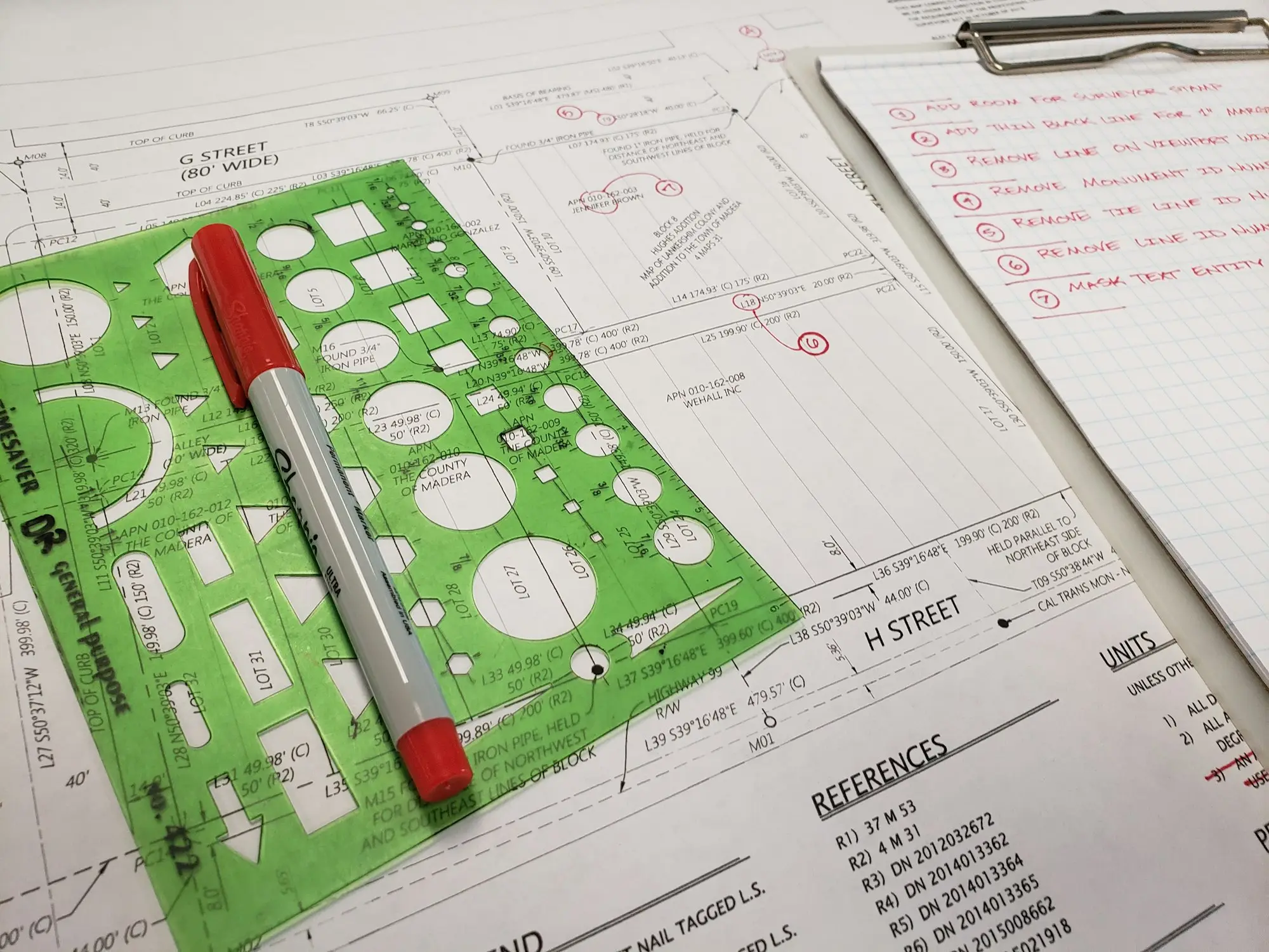 Site plan with a marker and a handwritten checklist on a clipboard, the kind of paperwork a lender asks for when building work isn't on council records